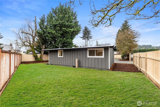 rear view of property featuring a fenced backyard, board and batten siding, and a yard