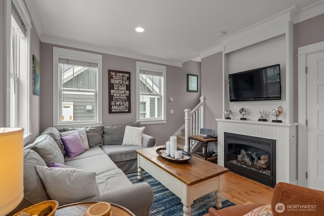 32 Madison Ln, Pacific Beach, WA 98571 - living area with crown molding, healthy amount of natural light, a glass covered fireplace, wood finished floors, and recessed lighting