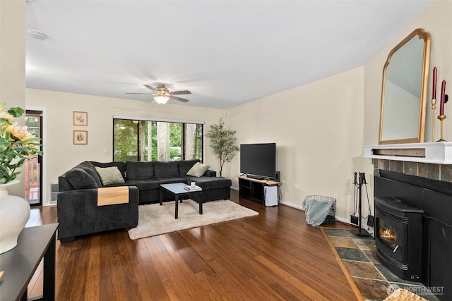 12427 129th Ave E, Puyallup, WA 98374 - living area with a wood stove, baseboards, dark wood finished floors, visible vents, and ceiling fan
