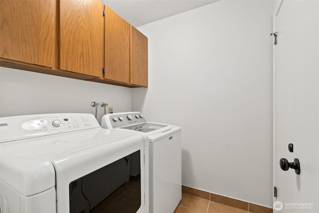 12427 129th Ave E, Puyallup, WA 98374 - laundry area with baseboards, separate washer and dryer, cabinet space, and light tile patterned floors