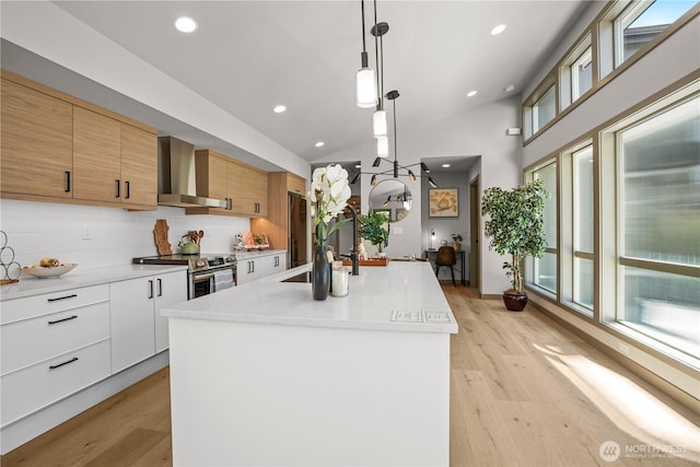 2324 NE 128th St, Seattle, WA 98125 - kitchen featuring wall chimney range hood, electric range, light wood finished floors, light countertops, and an island with sink