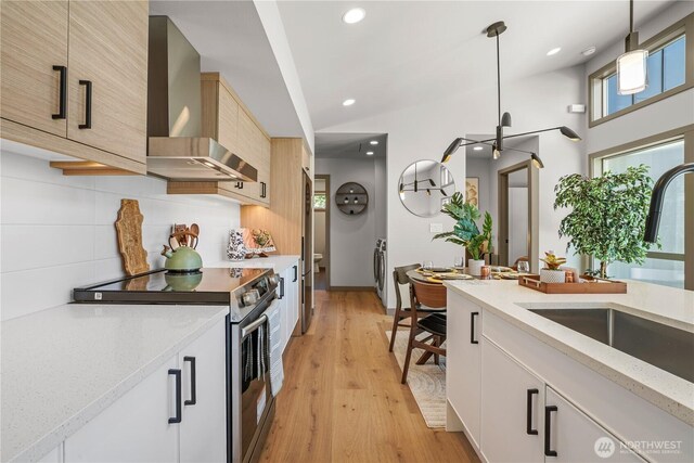 2324 NE 128th St, Seattle, WA 98125 - kitchen featuring appliances with stainless steel finishes, wall chimney range hood, backsplash, pendant lighting, and light stone counters