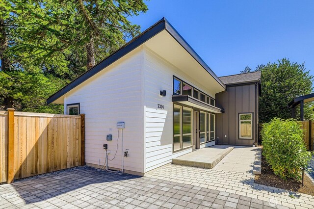 2324 NE 128th St, Seattle, WA 98125 - back of house with board and batten siding, a balcony, and a patio