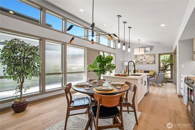 dining space with light wood-type flooring, lofted ceiling, and recessed lighting