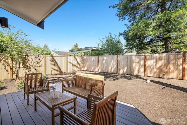 wooden terrace with a fenced backyard and an outdoor living space