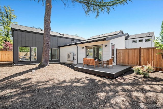back of house featuring board and batten siding, fence, a wooden deck, and a cooling unit