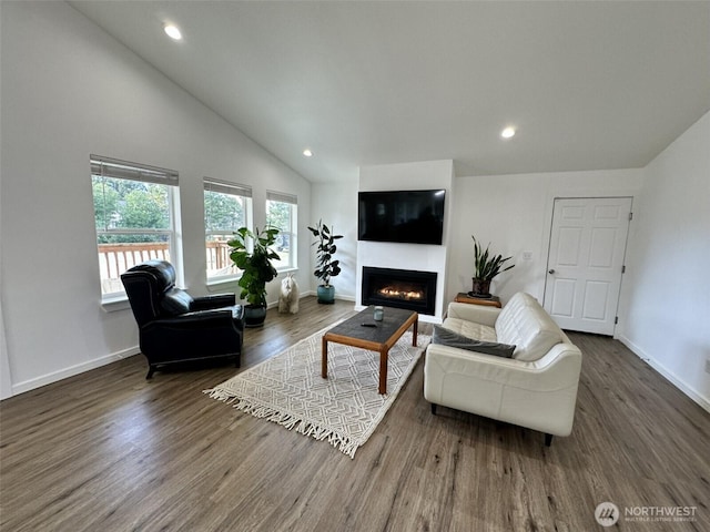 living area with baseboards, a lit fireplace, wood finished floors, and recessed lighting