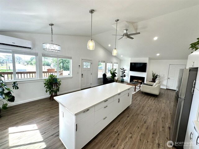 kitchen featuring a ceiling fan, dark wood-style flooring, an AC wall unit, freestanding refrigerator, and white cabinets