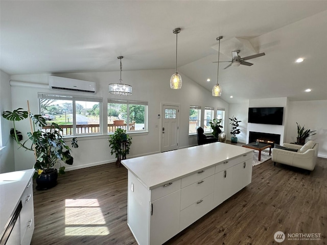 kitchen with dark wood-style floors, an AC wall unit, ceiling fan, and plenty of natural light