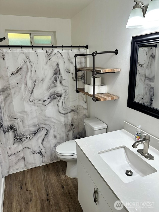 full bath with curtained shower, toilet, vanity, and wood finished floors