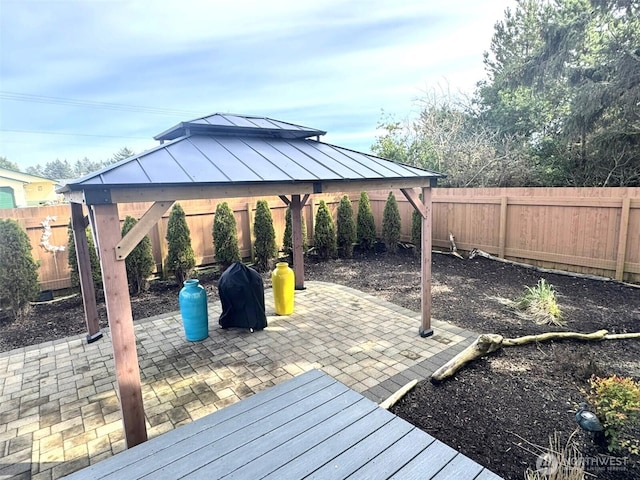 deck featuring a fenced backyard, a gazebo, and a patio