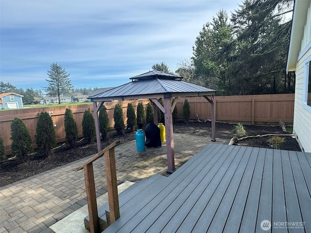 wooden terrace featuring a fenced backyard, a gazebo, and a patio area