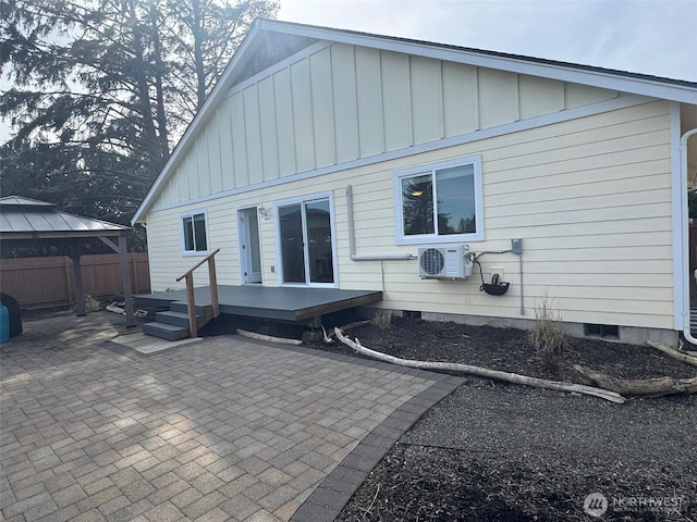 back of house with a gazebo, a patio, and board and batten siding