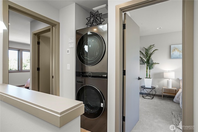 laundry area with stacked washing machine and dryer and carpet