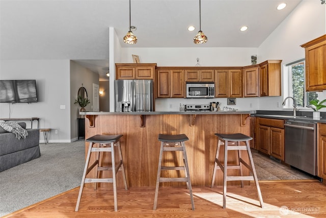 11320 S Stangland Rd, Medical Lake, WA 99022 - kitchen featuring a kitchen breakfast bar, a sink, appliances with stainless steel finishes, and brown cabinetry