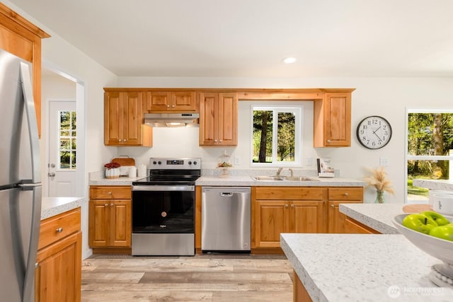 kitchen featuring under cabinet range hood, plenty of natural light, appliances with stainless steel finishes, and light countertops