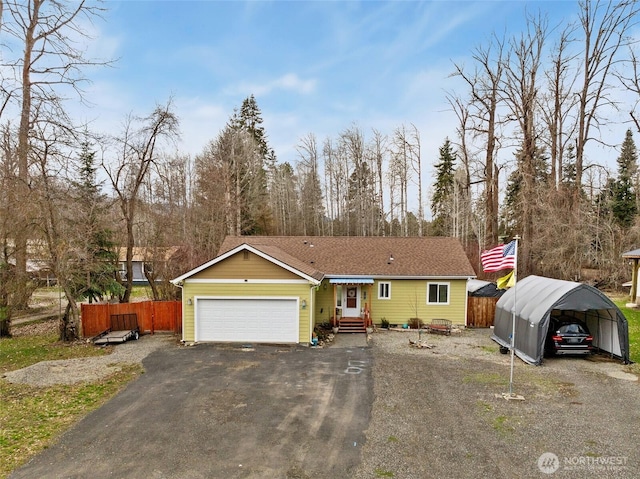 view of front facade with aphalt driveway, a detached carport, entry steps, fence, and an attached garage