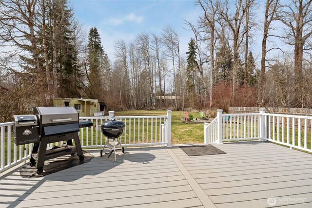 wooden terrace with a yard and fence