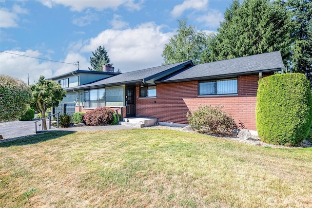 2302 126th Avenue Ct E, Edgewood, WA 98372 - view of front of house featuring brick siding, a front lawn, and a chimney