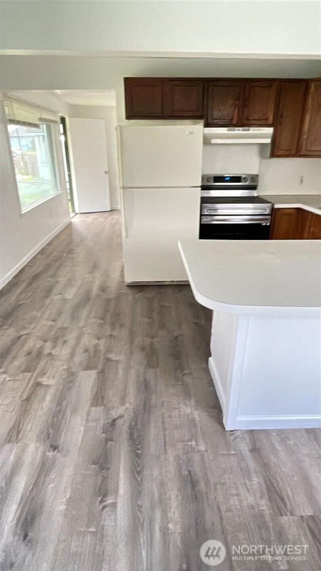 313 N E St, Aberdeen, WA 98520 - kitchen featuring freestanding refrigerator, stainless steel range with electric stovetop, under cabinet range hood, light countertops, and wood finished floors
