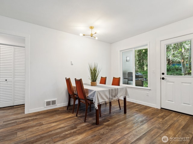 dining space with a chandelier, visible vents, baseboards, and wood finished floors