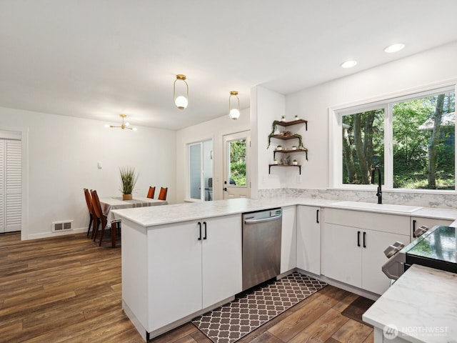 kitchen with a sink, a peninsula, dishwasher, and a healthy amount of sunlight