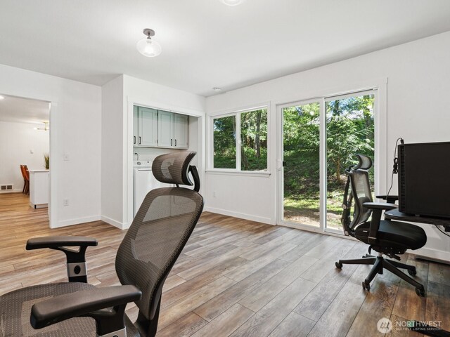 office featuring washer / clothes dryer, light wood-style floors, baseboards, and visible vents