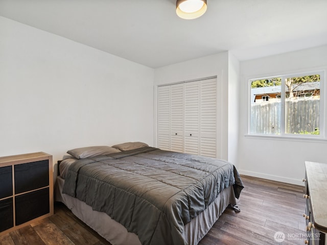 bedroom with a closet, baseboards, and dark wood-style floors