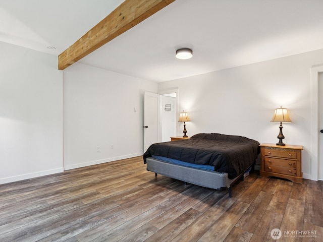 bedroom with beam ceiling, baseboards, and wood finished floors
