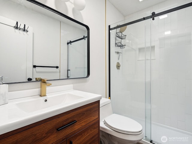full bathroom featuring toilet, vanity, and a shower stall