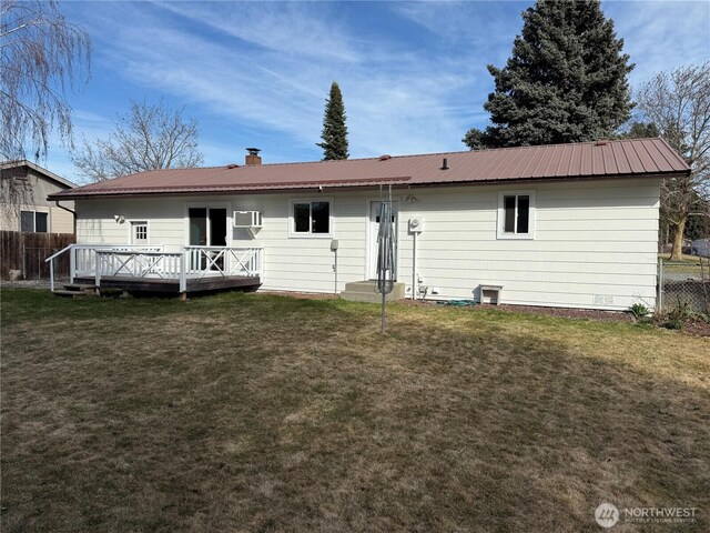 rear view of property with metal roof, fence, a chimney, and a yard