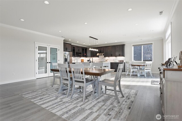 dining area featuring baseboards, ornamental molding, and recessed lighting