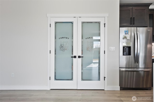 doorway to outside with baseboards, french doors, and light wood-type flooring