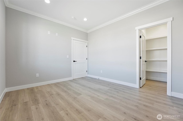 unfurnished bedroom with crown molding, baseboards, recessed lighting, light wood-style floors, and a walk in closet