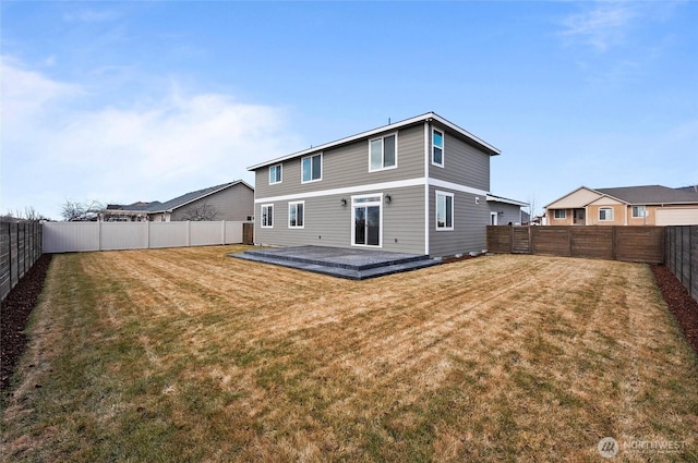 rear view of house with a fenced backyard and a lawn