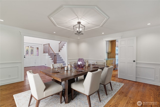 dining area with a decorative wall, stairway, crown molding, a chandelier, and recessed lighting
