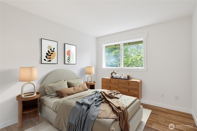 bedroom featuring baseboards and light wood finished floors