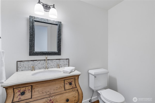 half bath featuring backsplash, toilet, vanity, baseboards, and wood finished floors