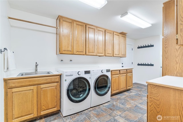 laundry area with cabinet space, independent washer and dryer, and stone finish floors