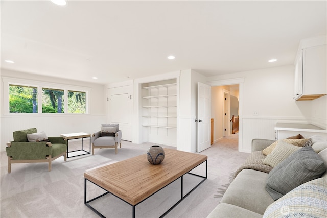 living room with light colored carpet, recessed lighting, wainscoting, and built in features