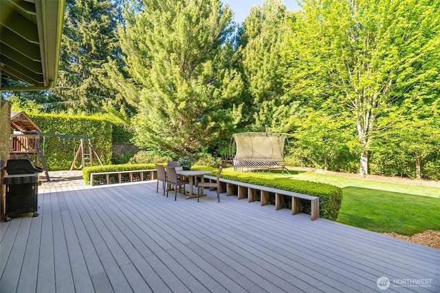 wooden terrace with a yard and a grill
