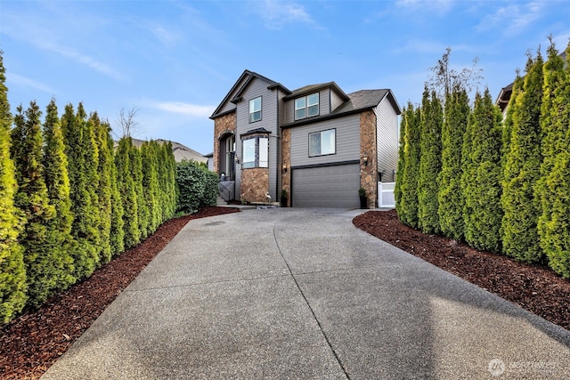 view of front of property with concrete driveway, a garage, and fence