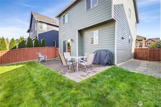 rear view of property with a fenced backyard, a patio area, and a yard