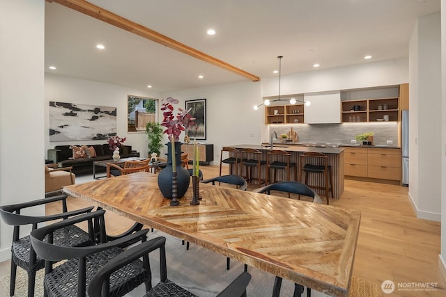 dining area with light wood finished floors and recessed lighting
