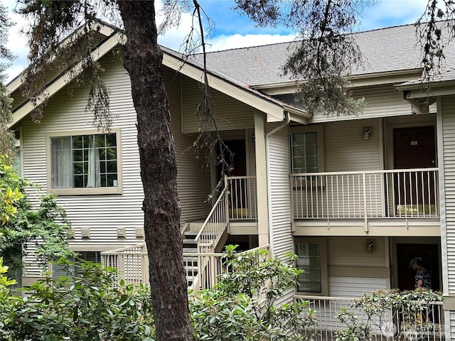 view of front of house with a balcony and roof with shingles