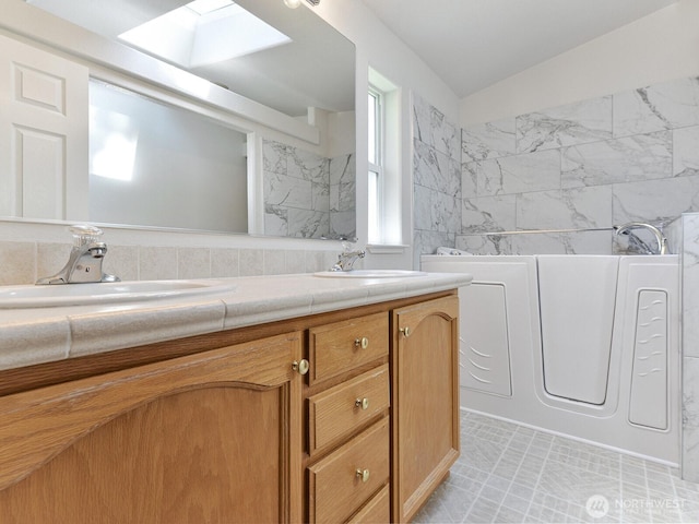 6012 91st Street Ct E, Puyallup, WA 98371 - full bath with lofted ceiling with skylight, double vanity, a sink, and a bathtub