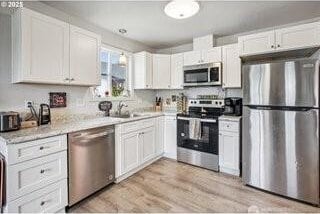 816 N Kelso Ave, Kelso, WA 98626 - kitchen featuring white cabinetry, light countertops, a sink, and appliances with stainless steel finishes