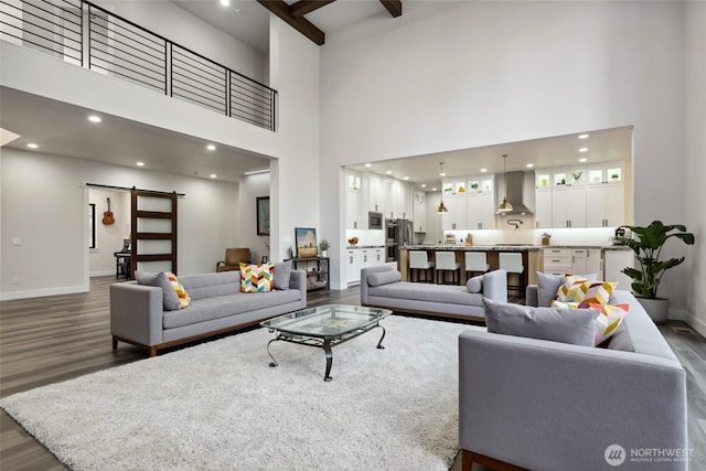 living area with baseboards, a barn door, dark wood-style floors, and recessed lighting