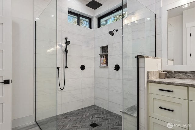 bathroom featuring a tile shower and vanity