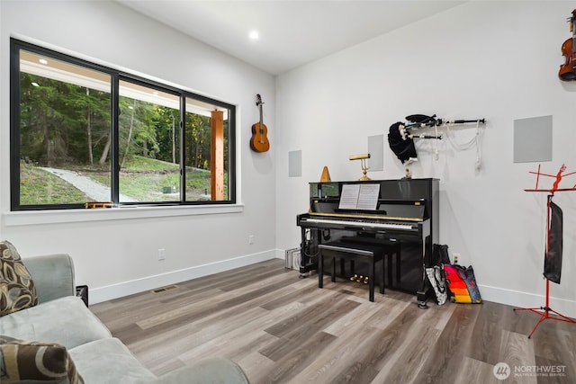 sitting room with baseboards, visible vents, and wood finished floors
